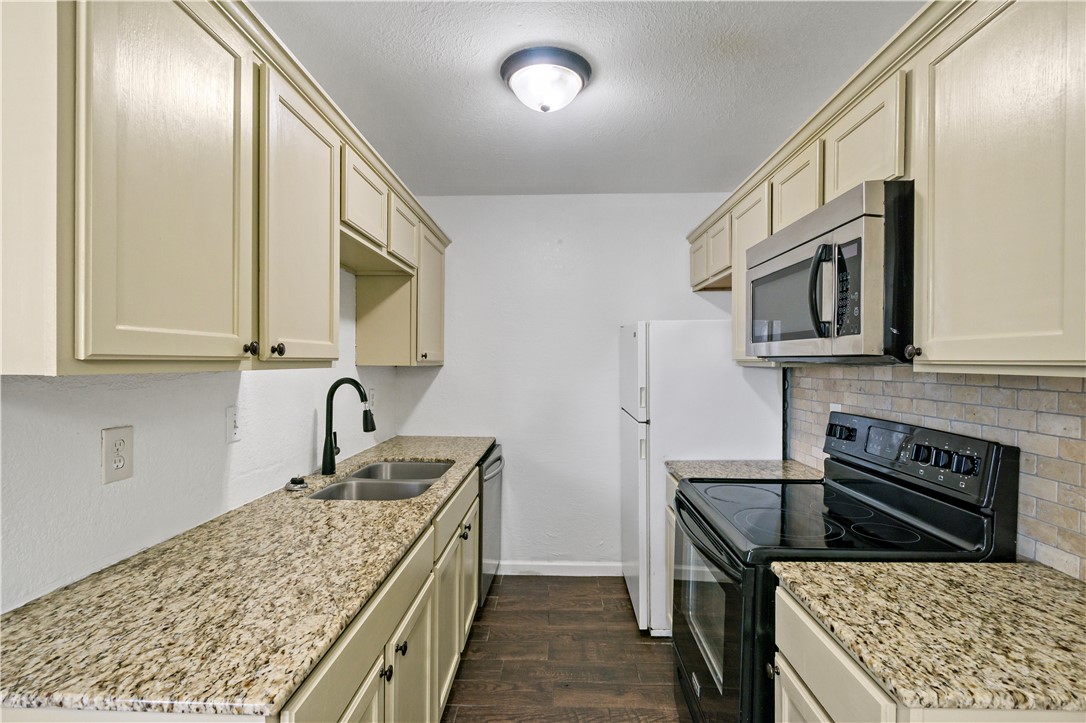 1503 Alpine Circle, Unit A College Station, TX 77840 - Photo 10 of 18 a kitchen with stainless steel appliances granite countertop a sink stove and cabinets