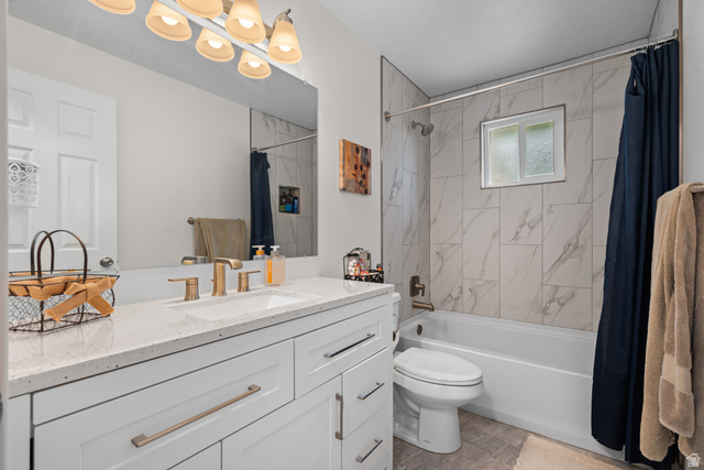 7659 State Street Midvale, UT 84047 - Photo 15 of 33 Bathroom featuring a white vanity with a light-colored countertop, brushed gold-tone faucet, and a large mirror