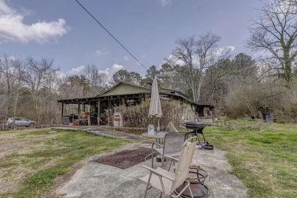 a backyard of a house with barbeque oven table and chairs