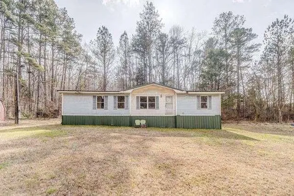 a view of house with wooden deck and a backyard