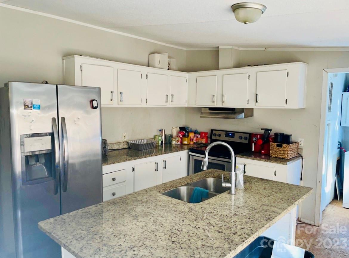 942 Stone Throw Drive Concord, NC 28025 - Photo 2 of 9 a kitchen with granite countertop a sink a refrigerator and cabinets