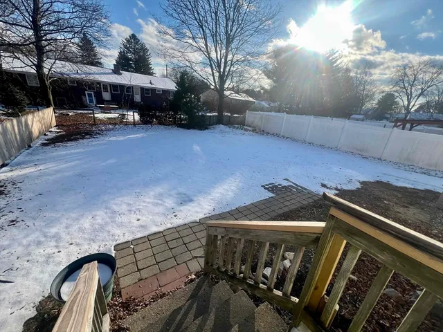 a view of a patio with table and chairs under an umbrella with a fire pit