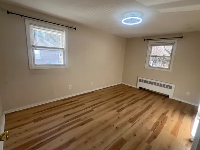 a view of a room with wooden floor and windows
