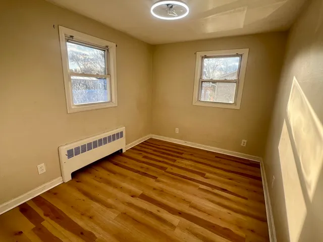 a view of a room with wooden floor and windows