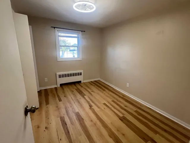 a view of a room with wooden floor and a window