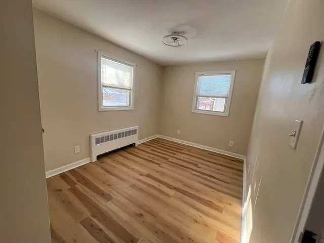 a view of a room with wooden floor and windows