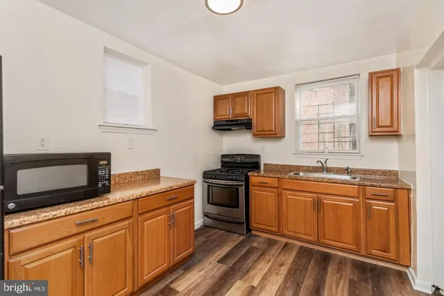 a kitchen with stainless steel appliances granite countertop a sink stove and microwave