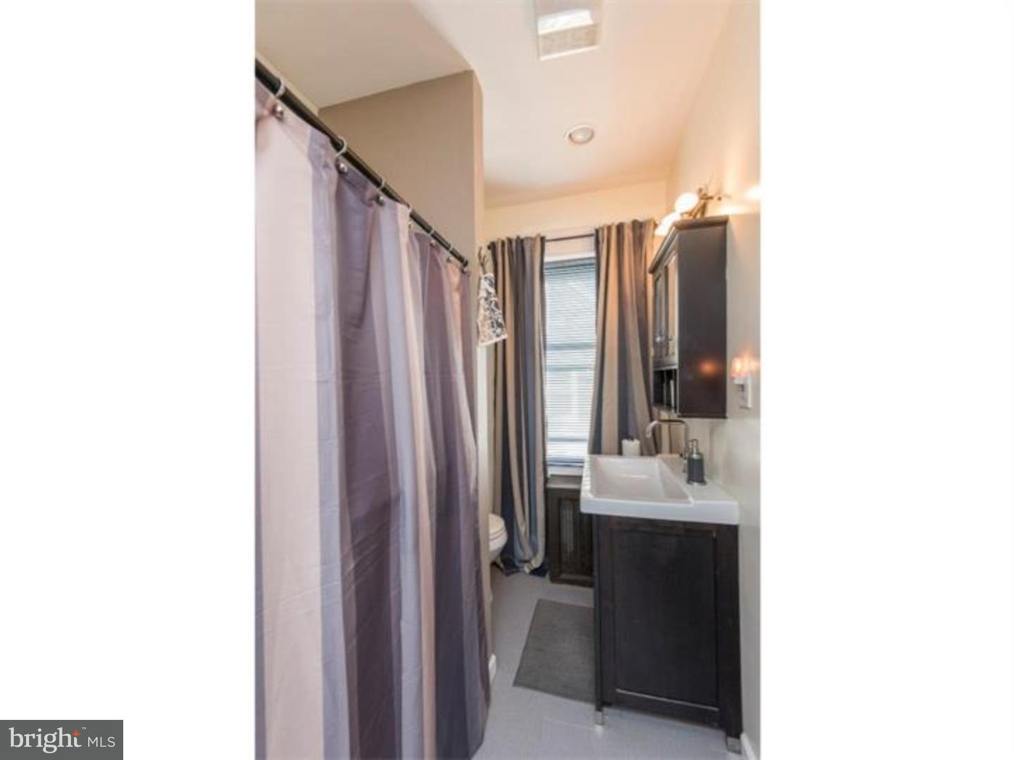 6817 Ridge Avenue Philadelphia, PA 19128 - Photo 22 of 22 a bathroom with a sink a mirror and shower