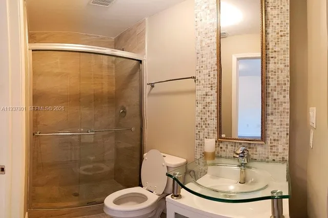 a bathroom with a sink toilet and shower
