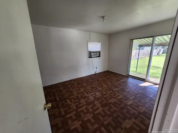 a view of a big room with wooden floor and windows