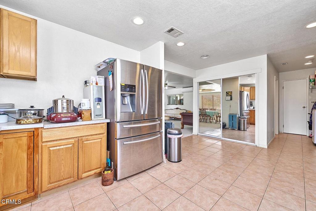 9494 Baker Road Lucerne Valley, CA 92356 - Photo 31 of 56 a kitchen with granite countertop a refrigerator and cabinets