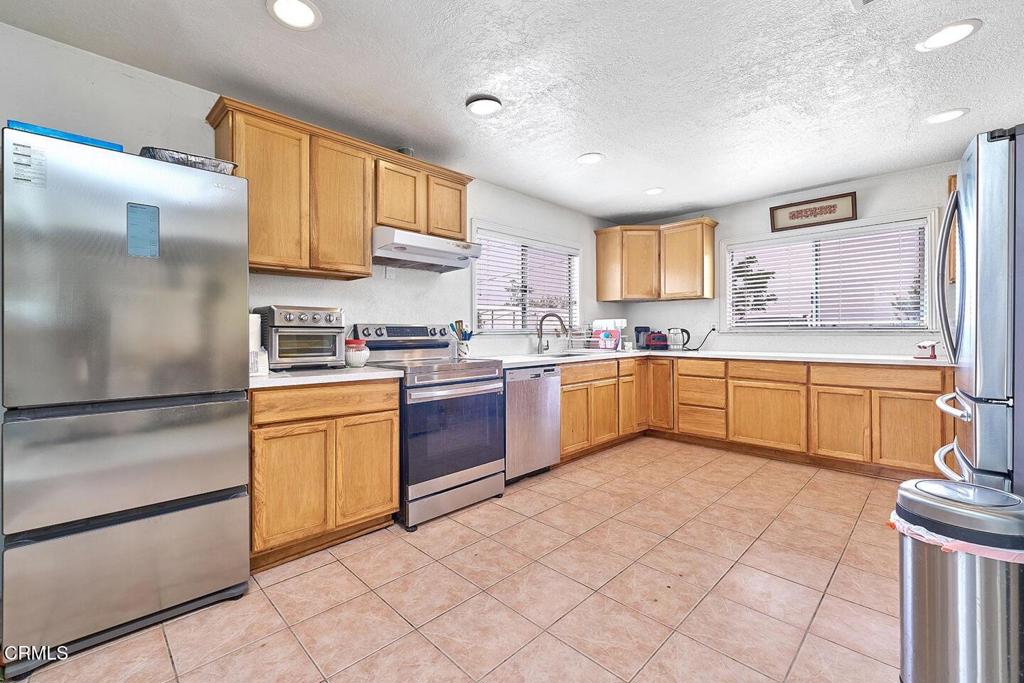 9494 Baker Road Lucerne Valley, CA 92356 - Photo 37 of 56 a kitchen with granite countertop a sink stainless steel appliances and cabinets