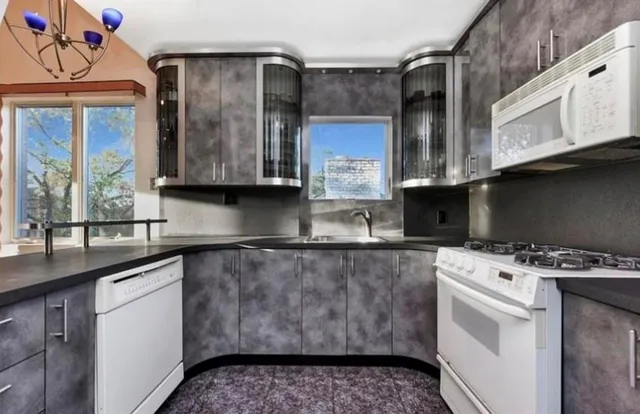 a kitchen with stainless steel appliances granite countertop a sink a stove and a microwave