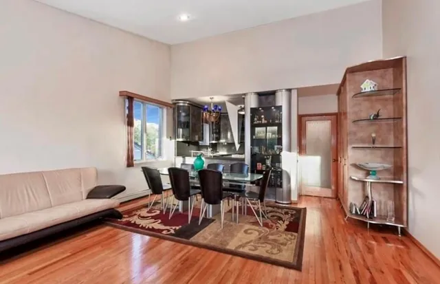 a living room with furniture hard wood floor and a kitchen view