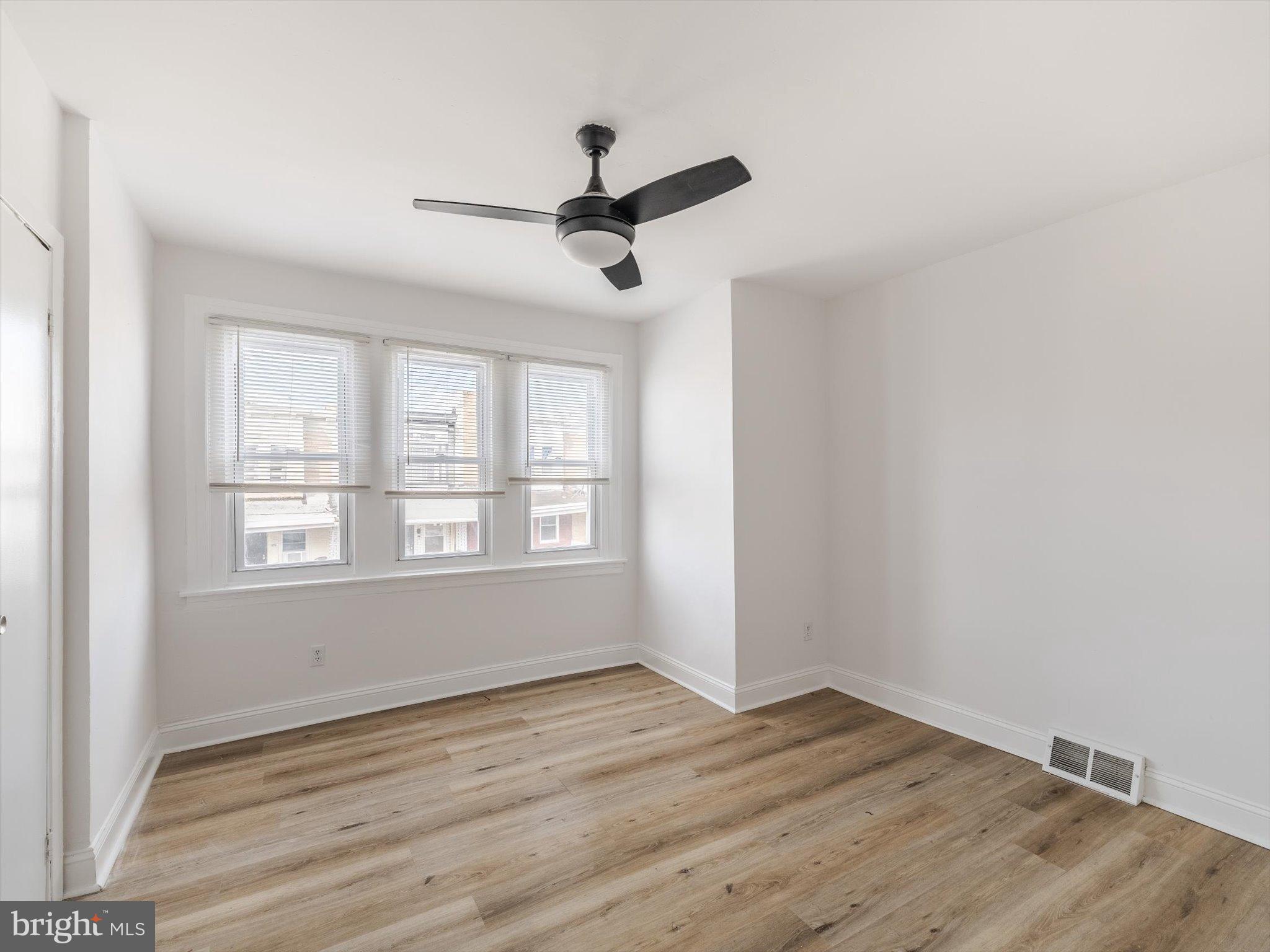 5428 Belmar Street Philadelphia, PA 19143 - Photo 12 of 25 an empty room with wooden floor and windows