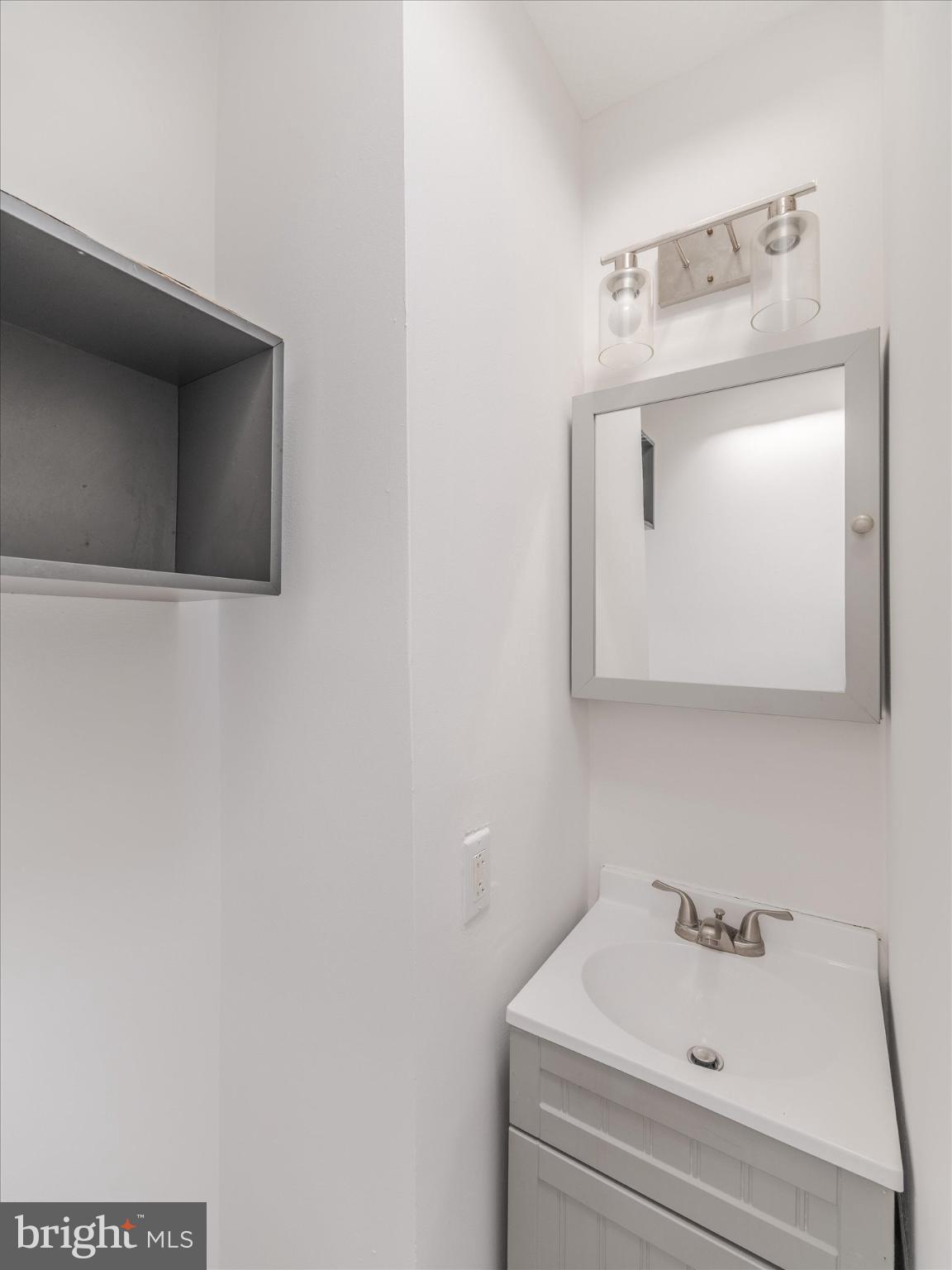5428 Belmar Street Philadelphia, PA 19143 - Photo 22 of 25 a bathroom with a sink and a mirror