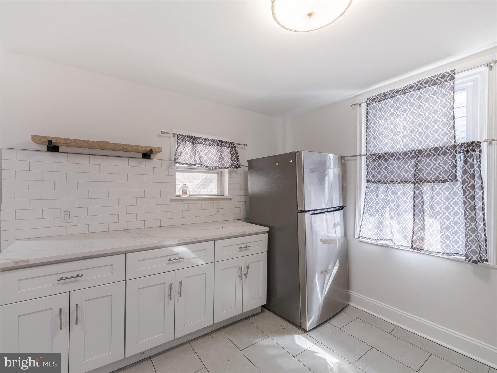 5428 Belmar Street Philadelphia, PA 19143 - Photo 9 of 25 a kitchen with a refrigerator a sink and cabinets
