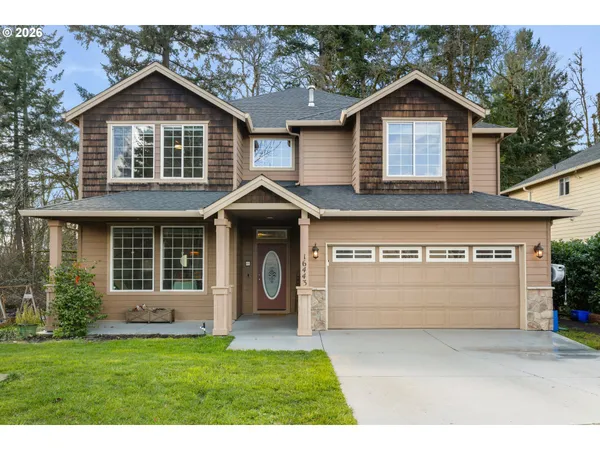 a front view of a house with a garden and garage