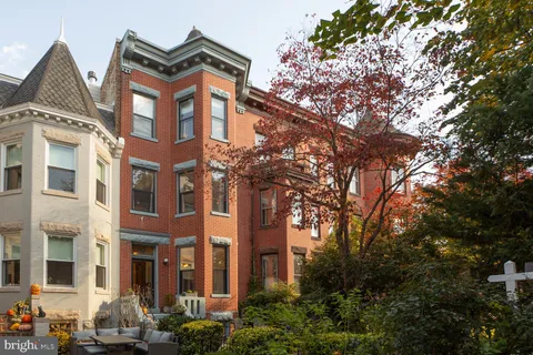 a view of a hallway with wooden floor and a living room