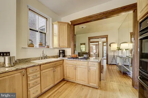 a dining room with furniture a chandelier and wooden floor