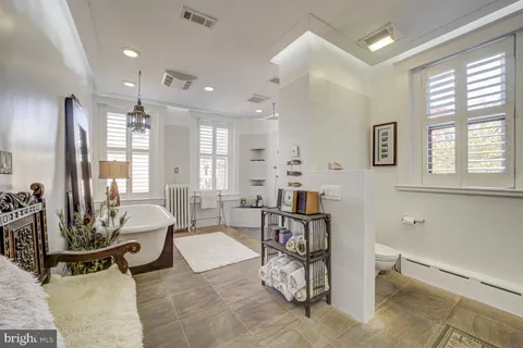 a spacious bathroom with a tub shower and window