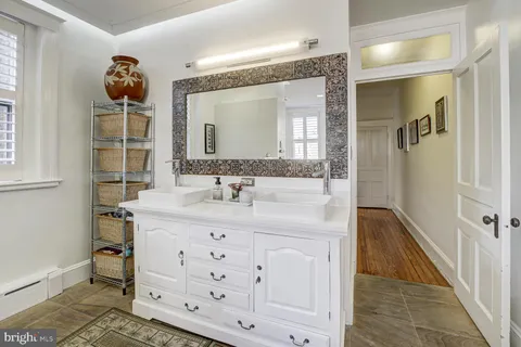 a living room with furniture a mirror and lamp