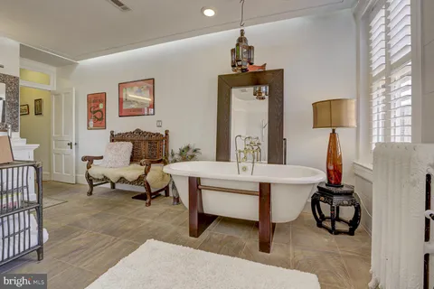 a view of a hallway with wooden floor and a bathroom
