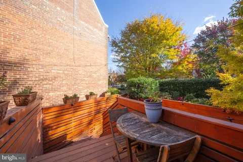 a outdoor sitting area with a couch and potted plants
