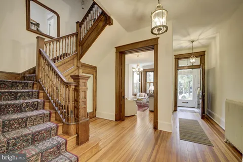 a view of a hallway with wooden floor and staircase