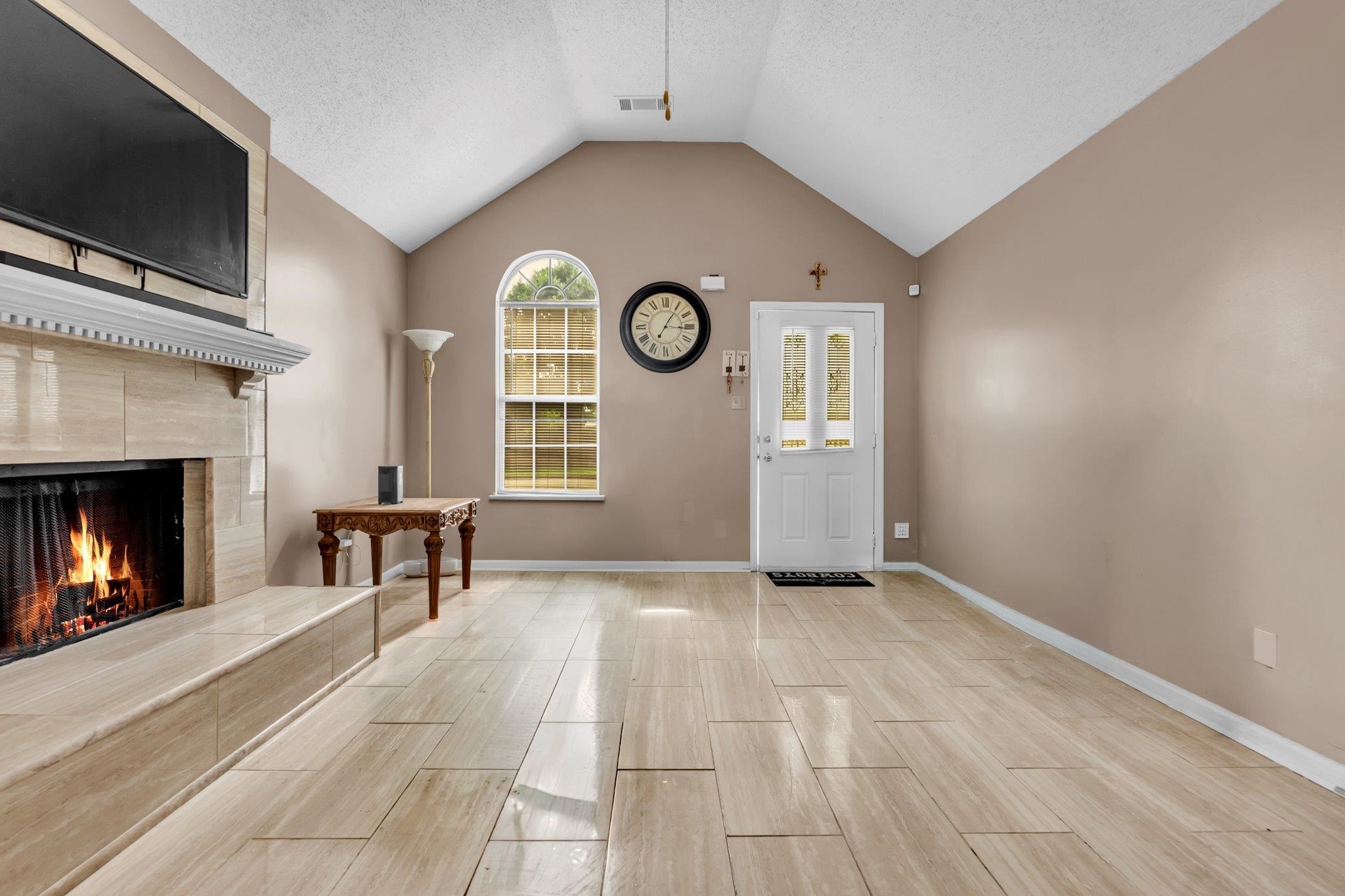 5930 Chadwell Road Millington, TN 38053 - Photo 4 of 17 Living area featuring a vaulted ceiling, light-toned wall paint, and wood-finish tile flooring
