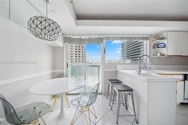 a living room with stainless steel appliances granite countertop furniture a refrigerator a stove a sink and a large window