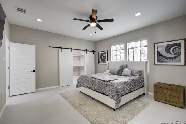 a bedroom with a large bed and a chandelier