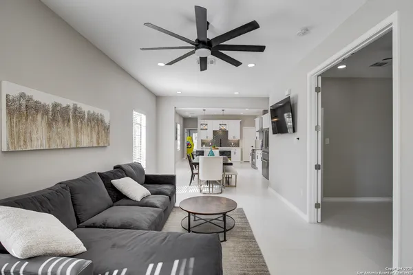 a living room with furniture and a view of kitchen