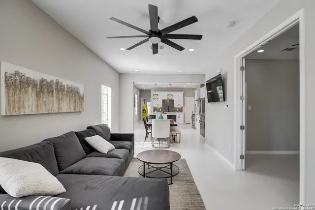 a living room with furniture and a view of kitchen