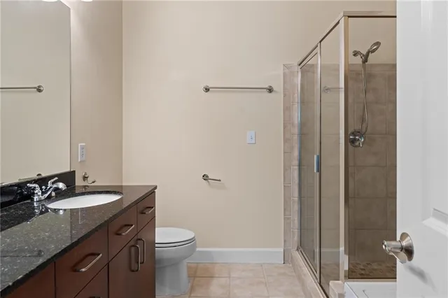 a bathroom with a granite countertop sink toilet and shower