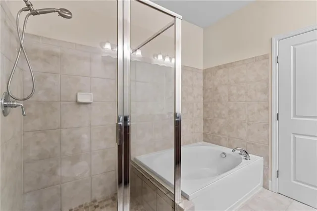 a bathroom with a tub a shower and a sink