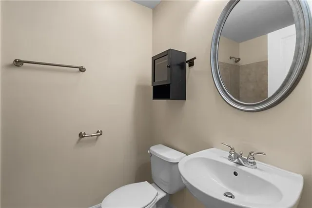 a bathroom with a sink mirror and toilet