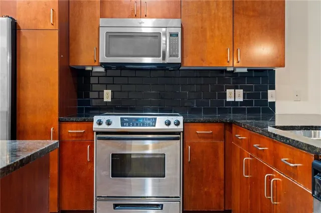 a kitchen with stainless steel appliances granite countertop a stove and a microwave