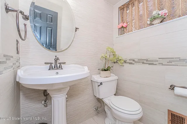 a bathroom with a toilet sink and mirror