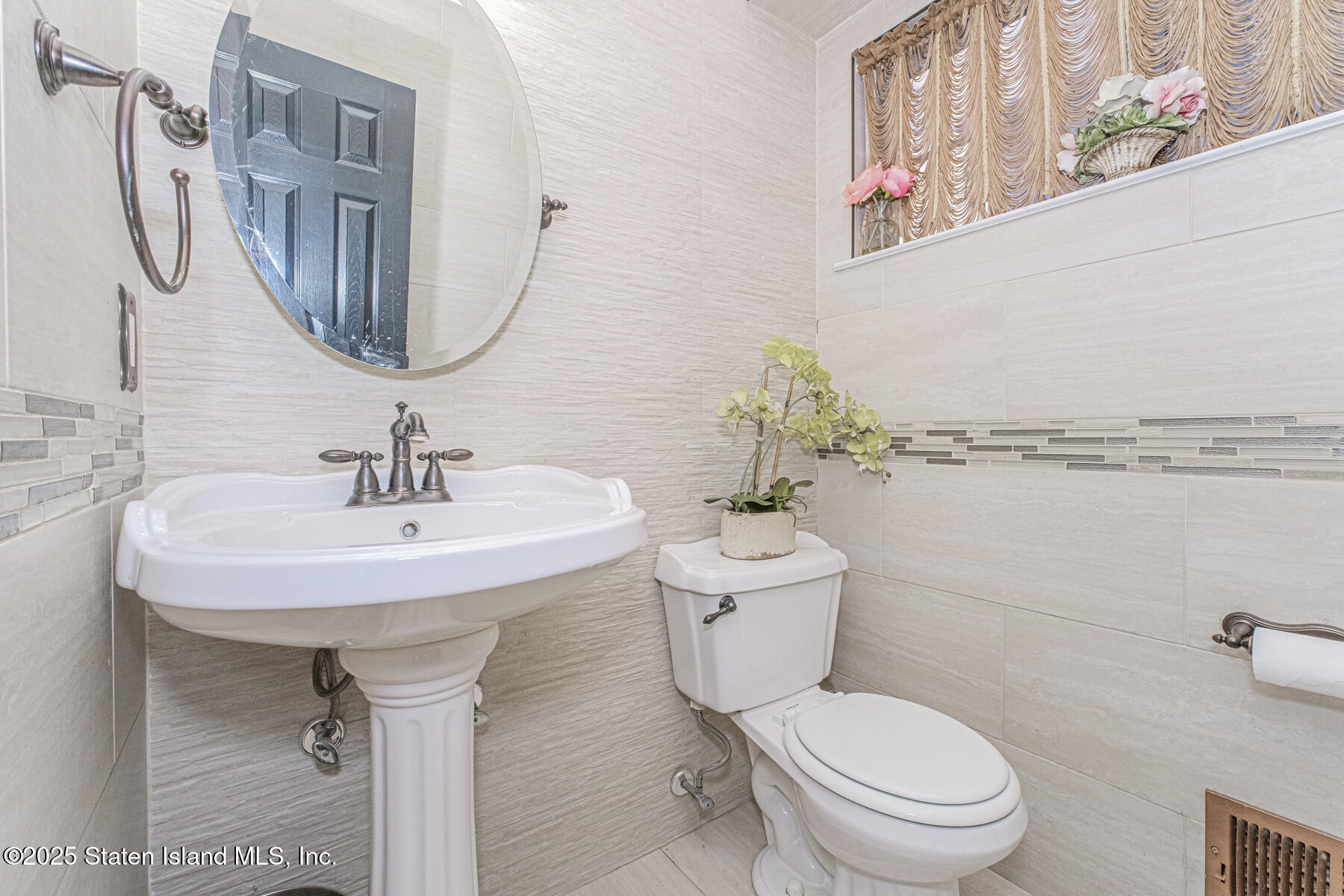 122 Clay Pit Road Staten Island, NY 10309 - Photo 11 of 26 a bathroom with a toilet sink and mirror