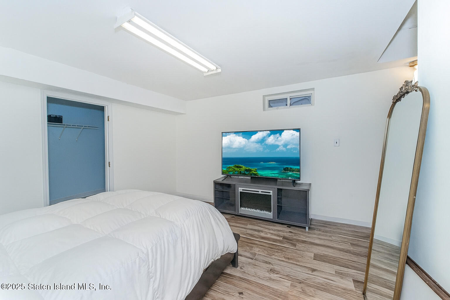 122 Clay Pit Road Staten Island, NY 10309 - Photo 21 of 26 a bedroom with a bed and flat screen tv