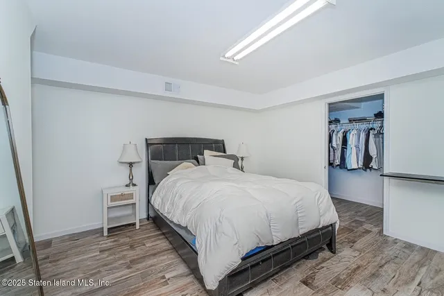 a bedroom with a bed and a wooden floor
