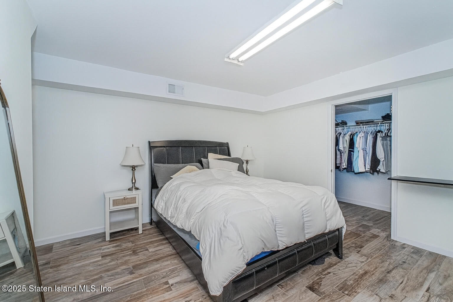 122 Clay Pit Road Staten Island, NY 10309 - Photo 22 of 26 a bedroom with a bed and a wooden floor