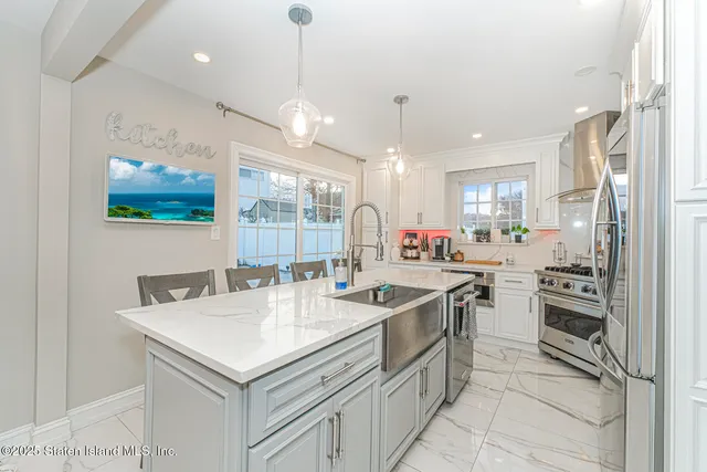 a kitchen with stainless steel appliances granite countertop a sink and a refrigerator