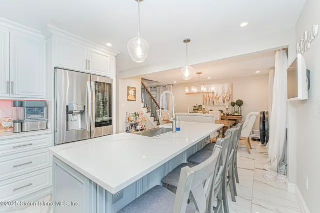 a large kitchen with a kitchen island wooden floor and stainless steel appliances