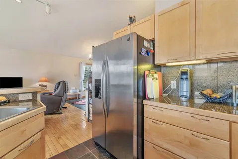 a kitchen with stainless steel appliances granite countertop a refrigerator and a stove