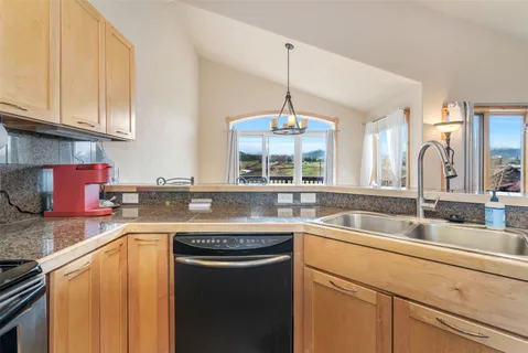 a kitchen with stainless steel appliances granite countertop a sink a stove and cabinets