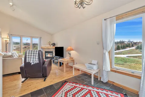 a living room with furniture and a floor to ceiling window