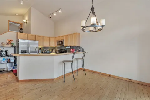 a kitchen with stainless steel appliances a dining table chairs and a chandelier