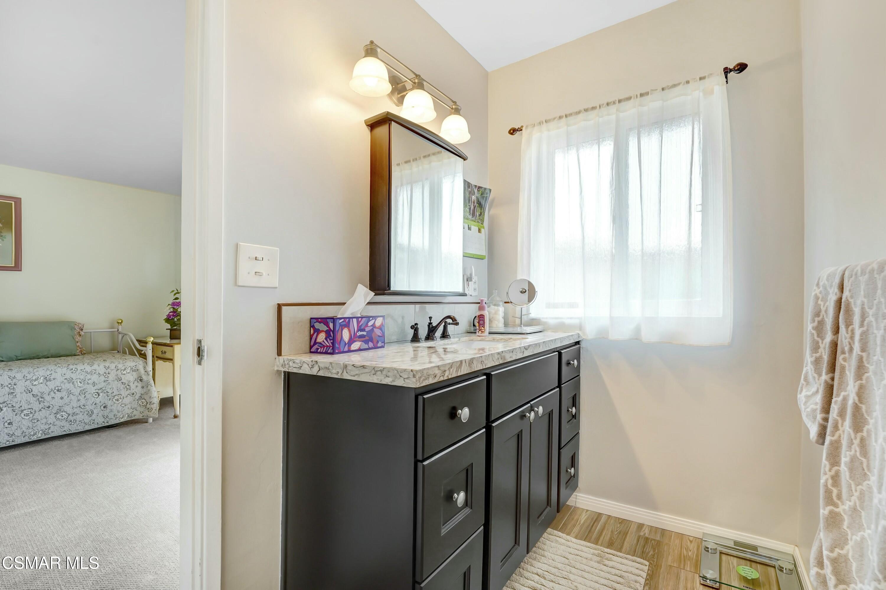 3075 Reservoir Drive Simi Valley, CA 93065 - Photo 13 of 20 a bathroom with a granite countertop sink and a mirror